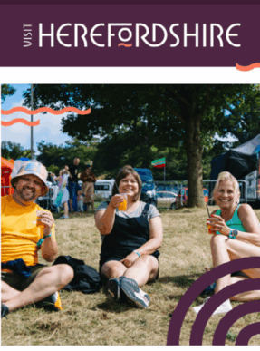 three people sitting on the grass at a festival